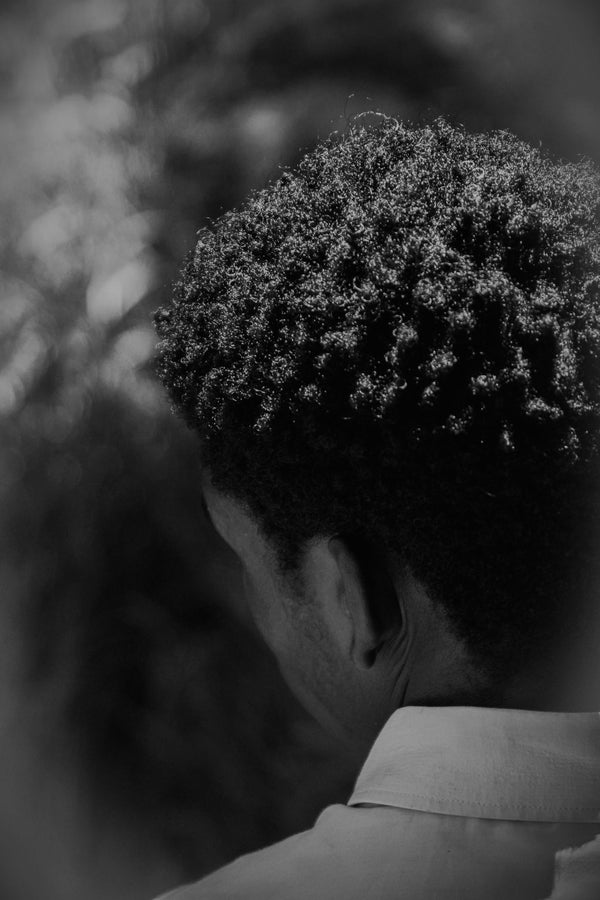 Woman with defined afro-textured curly hair, refreshed between wash days with natural curl care products